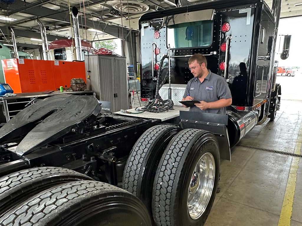 appraiser inspecting used semi-truck in auto shop